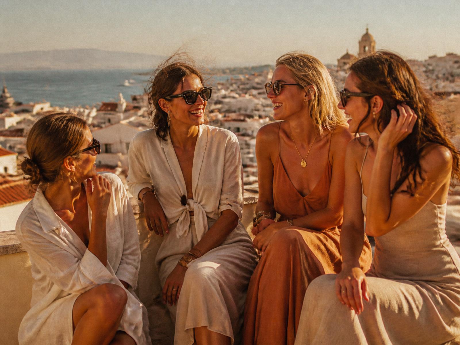 Women travellers together on a sunlit coastal terrace